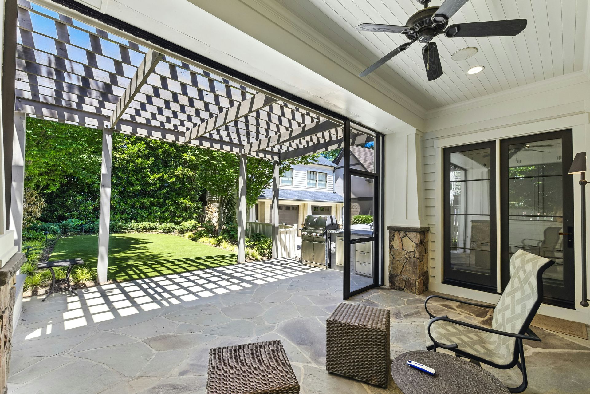 Covered patio with outdoor seating and grill.